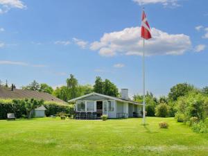 a flag pole in the yard of a house at 6 person holiday home in Jægerspris-By Traum in Jægerspris