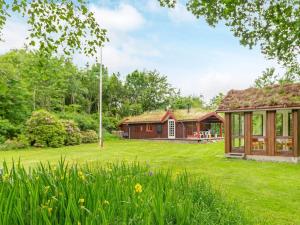 a house with a green yard with a large building at 6 person holiday home in Roslev-By Traum in Roslev