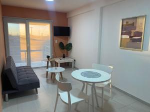 a living room with a couch and a table and chairs at Edificio Hudson in Rawson