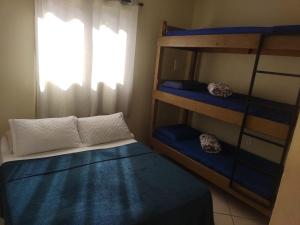 a bedroom with two bunk beds and a window at Casa e Kitnet - Praia Grande Centro in Arraial do Cabo