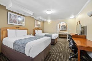 a hotel room with two beds and a desk at Alexis Park San Francisco in San Francisco