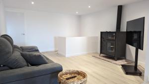 a living room with a couch and a flat screen tv at Casa rural Can Joaquinet Rossell in Rosell +4 photos