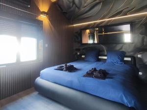 a bedroom with a blue bed with three animals on it at R luxury piscine et spa privatifs in Colmar +15 photos