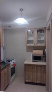 a kitchen with wooden cabinets and a stove top oven at Apartament Pułaskiego in Rzeszów