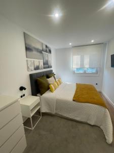 une chambre avec un grand lit et une table de chevet dans l'établissement Villa Valentina Cíes, à Vilagarcía de Arousa