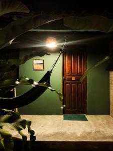 a room with a green wall and a wooden door at Pousada Moreré in Ilha de Boipeba