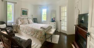 a bedroom with a bed and a tv and windows at Au Gré Du Temps - Gîte B&B in Shefford +56 photos