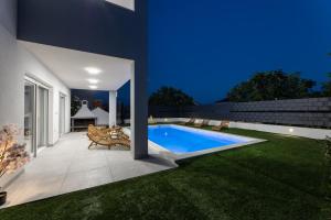 einen Hinterhof mit Pool in einem Haus in der Unterkunft Vila MaMe in Kaštela + 20 Fotos