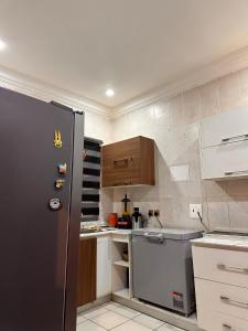 a small kitchen with a refrigerator and a sink at Savannah Homes in Abuja