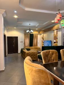 a living room with couches and a table and chairs at Savannah Homes in Abuja +8 photos