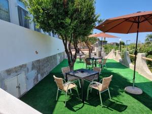 a patio with tables and chairs and an umbrella at Casa Bice in Forio d'Ischia