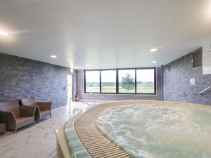a large hot tub in a room with a couch at Mallard Cottage in Penrith