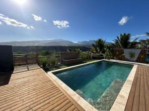 a swimming pool on a deck with a view of the mountains at Villa Eclats Panoramiques in Saint-Pierre