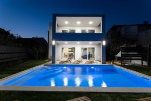 eine Villa mit einem Swimmingpool vor einem Haus in der Unterkunft Vila MaMe in Kaštela