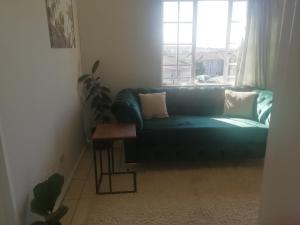 a blue couch in a living room with a window at Ekya in Randburg