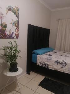 a bedroom with a bed and a plant on a table at Ekya in Randburg