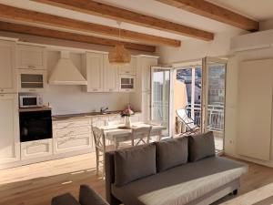 a living room with a couch and a table in a kitchen at Attico Saluzzo centro in Saluzzo