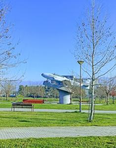 un avion est assis dans un parc avec un banc dans l'établissement LALA New Apartment, à Skopje