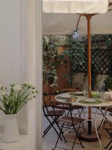 a table with chairs and an umbrella in a room at Viadelloca35 in Rome