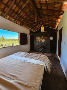 a bedroom with a large bed with a large window at Refúgio CAJUÍ in Barreirinhas