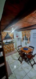 - une table et des chaises dans une pièce avec cuisine dans l'établissement Pouso da Cajaíba - Chalé Pedaço de Céu, à Parati