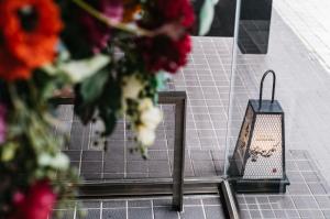 un reflet de fleurs dans une fenêtre avec une bougie dans l'établissement Hotel Resol Trinity Kanazawa, à Kanazawa