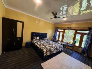 a bedroom with a bed and a ceiling fan at Maqsoom Villa I Entire Villa Near Srinagar Airport and Dal Lake I 4 BR in Srinagar