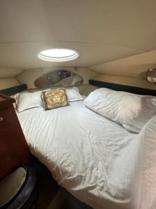 迪拜Yacht boat 2 Beds 1 Bath Dubai Eye Dubai Marina JBR的一张白色大床,上面有枕头