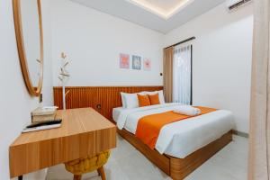 a bedroom with two beds and a desk at Swaripuna Villa by Nandara Hospitality in Salakan