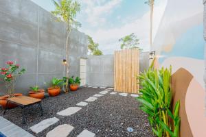 a courtyard with potted plants and a fence at Swaripuna Villa by Nandara Hospitality in Salakan