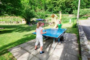 dos chicas jugando ping pong en una mesa de ping pong en Eco-Hotel Cristallina en Coglio