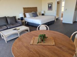 a living room with a table and a bed and a couch at Tuileries at De Bortoli Rutherglen in Rutherglen