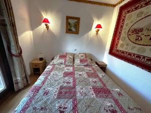 a bedroom with a bed with a quilt on it at Appartement montagne 6 pers, rénové, balcon sud/ouest - FR-1-452-389 in Les Menuires