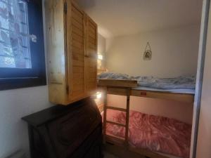 ein Schlafzimmer mit einem Etagenbett und einem Holzschrank in der Unterkunft Duplex 3 chambres au pied des pistes à Montgenèvre - FR-1-266-230 in Montgenèvre + 6 Fotos