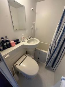 a bathroom with a toilet and a sink and a mirror at GEGE house 201室 in Osaka