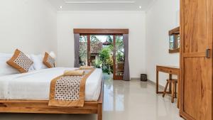 乌布Marwati Guest House的一间带大床和书桌的卧室