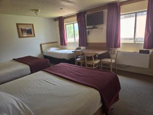 a hotel room with two beds and a table at Hatch Station Bryce Canyon in Hatch