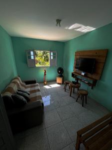a living room with a couch and a flat screen tv at Descanso Milagres in São Miguel dos Milagres