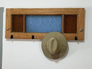 a hat on a wall next to a window at Sierras in La Falda