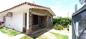 a small house with a stone wall at Sierras in La Falda