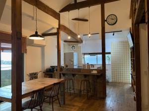 五岛masuda villa的厨房以及带桌子和时钟的用餐室。