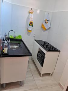 a small kitchen with a sink and a stove at Casa Central! Localização Privilegiada! in Porto Seguro