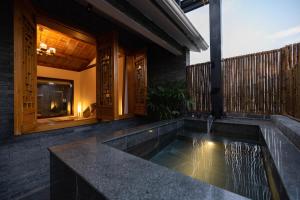 a house with a plunge pool on a balcony at 青城山泉青小院温泉中式民宿 in Taiping