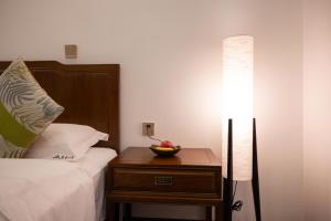 a lamp and a bowl of fruit on a table next to a bed at 青城山泉青小院温泉中式民宿 in Taiping