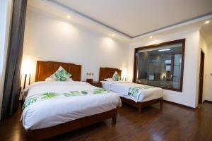 a bedroom with two beds and a large window at 青城山泉青小院温泉中式民宿 in Taiping