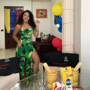 Una mujer con un vestido verde parada en una habitación en Colonial zone great location private room, en Santo Domingo