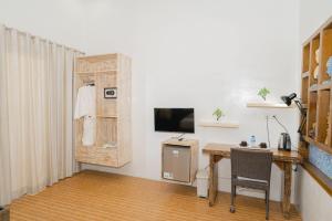 a room with a desk and a tv and a table at Pandawa Resort & Spa Seaview in Nusa Penida