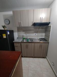 a small kitchen with a sink and a refrigerator at Hermoso Apartaestudio a 25 minutos del parque del café in Armenia