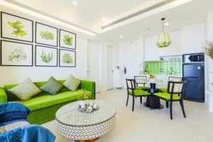 a living room with a green couch and a table at Rosie Hillside Seaview Phu Quoc Apartment in Phu Quoc