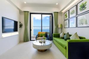 a living room with a green couch and a table at Rosie Hillside Seaview Phu Quoc Apartment in Phu Quoc